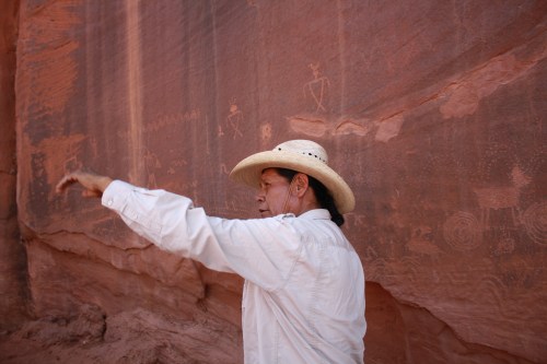 Clint Westwood of Monument Valley Safari in front of ancient petroglyphs