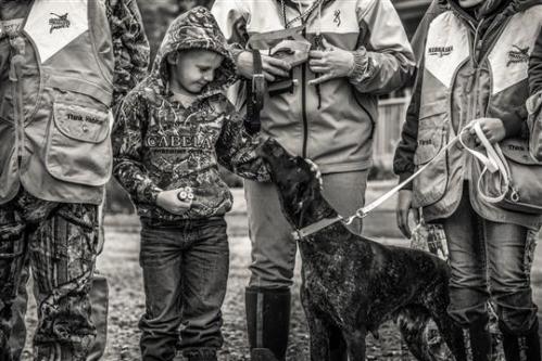 Kahne Packer and his German Shorthaired Pointer anxiously wait to set food afield at a youth mentor pheasant hunt at Cub Creek Hunting in Beatrice.  Photo by Kaleb White